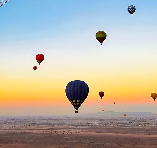 Hot-air balloons at sunrise over the desert near Marrakech